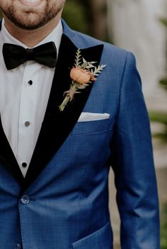 a man wearing a blue suit and bow tie