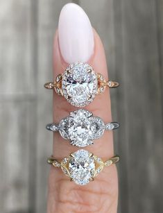 three diamond rings on the finger of a woman's hand, with one ring in between them