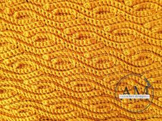 an orange knitted blanket with the letter m on it's center and bottom corner