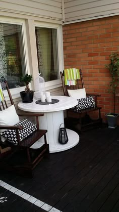 two chairs and a table on a porch