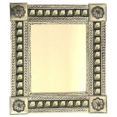 an ornate silver frame with flowers and leaves on the border is shown in this image