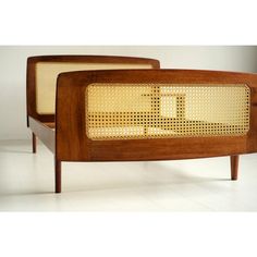 a pair of mid century style wooden and wicker beds