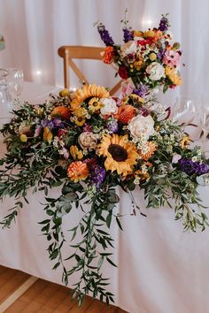 the table is set with sunflowers and greenery for an elegant wedding reception