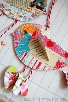 some paper birds are hanging from strings on a piece of crafting paper that has been cut out