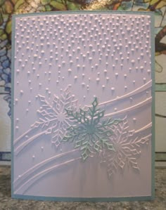 a card with snowflakes on it in front of a stained glass wallpaper