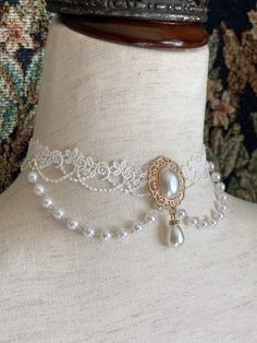 This beautiful Rococo & Regency inspired choker necklace is dripping in faux pearls, and white floral lace; making it the perfect historical accessory to tie-together an outfit for a ball or promenade! Sizing: One SizeNeck Circumference 12-16 Inches / 30.5-40.5 CentimetersAdjustable claw clasp Chocker Neckless Pearls, Rococo Inspired Outfits, Rococo Necklace, Rococo Outfit, Rococo Accessories, Rococo Jewelry, Regency Accessories, Regency Jewelry, Intricate Jewelry