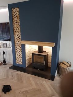 a living room with a fire place and wood stacked on the fireplace mantels