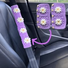 two crocheted flowers are attached to the front seat of a car, with an arrow pointing at them