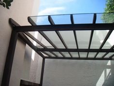 an outdoor area with a metal frame and glass door on the side of a building