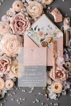 the wedding stationery is surrounded by flowers and confetti, such as peonies