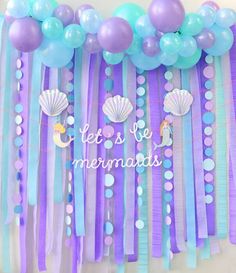 there are balloons and streamers on the wall with mermaids in them for a birthday party