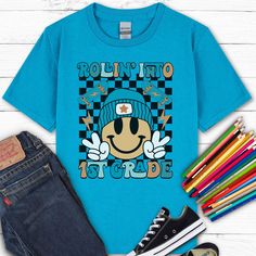 Go back to school in style with this "Rollin Into 1st Grade" shirt! Our kids heavy cotton tee is perfect for everyday use. The fabric is 100% cotton for solid colors. Polyester is included for heather-color variants.  ** HOW TO ORDER ** Select size + color from the drop down menus Add to cart + place order  ** SIZING ** Please refer to sizing charts for accurate measurements.  ** SHIPPING ** Ships in 2-5 business days ** ABOUT OUR SHIRTS ** * Gildan Brand * Solid Colors: 100% Cotton * Heather Co Blue Graphic Print T-shirt For School Events, Blue Pre-shrunk T-shirt For School Events, Trendy Blue T-shirt For School, School T-shirt With Graphic Print And Relaxed Fit, Relaxed Fit Graphic Print T-shirt For School, Blue Graphic Print Top, Blue College Style T-shirt With Graphic Print, Trendy Blue School T-shirt, Blue School Spirit Shirt With Graphic