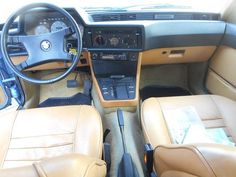 the interior of a car with tan leather seats and dashboard controls, including steering wheel