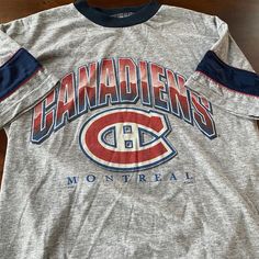 "Title: Habs T-shirt Size: Small Made in: Canada Material: Cotton Pit to pit: 18\" Length: 25\"" Graphic Tee With Team Logo And Crew Neck, Graphic Tee For Sports Season, Sports Season Text Print Crew Neck T-shirt, Graphic Tee With Team Logo In Tri-blend Fabric, Graphic Tee With Team Logo In Tri-blend, Tri-blend Graphic Tee With Team Logo, Sports Season Graphic Tee With Crew Neck, Sports Season Graphic Print Crew Neck Shirt, Montreal Canadiens