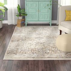 a living room scene with a couch, chair and large rug on the hardwood floor