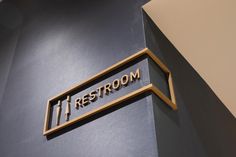 there is a sign that says restroom on the side of a wall in a building