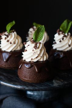 three chocolate desserts with whipped cream and mint leaves