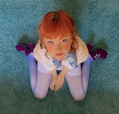 a doll is sitting on the floor with skis in her hands and wearing blue tights