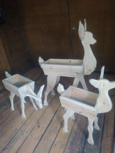 four white deer planters sitting on top of a wooden floor