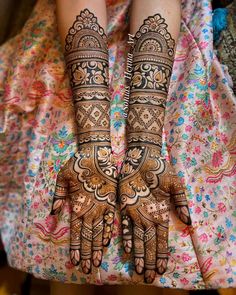 two hands with henna tattoos on them