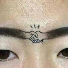 a close up of a person's face with tattoos on their forehead and eyebrows