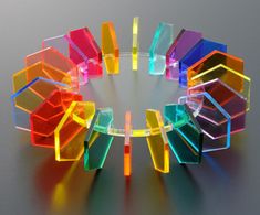 a multicolored glass object sitting on top of a white table next to a gray wall