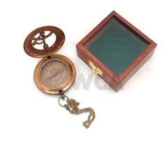 an open wooden box with a compass and chain attached to it on a white background