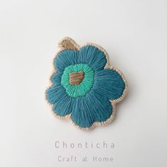 a blue flower brooch sitting on top of a white table