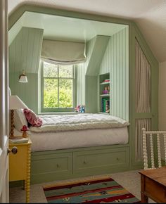 a bedroom with green painted walls and white bed in the corner, next to a window