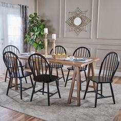 a dining room table with six chairs and a rug on the floor in front of it