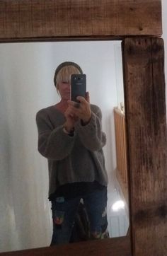 a woman taking a selfie in front of a mirror