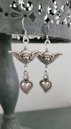 Adorn yourself with these  beautiful antique silver metalwork sweet cherub angels and milagros hearts  * Both sides are the same. * Lightweight.  These earrings are  2.0" inches long.  All jewelry materials are resourced from The United States, Italy , Portugal, Spain and The United Kingdom.  All jewelry is free of lead, free of nickel and eco-friendly. Light weight earrings.  All my jewelry is made and designed with love for you to express yourself and your life with happiness, beauty and spiri Victorian Jewelry Earrings, Silver Victorian Jewelry, Sacred Heart Earrings, Cherub Earrings, Alt Accessories, Jewelry Materials, Angel Heart, Earrings Antique, Antique Earrings