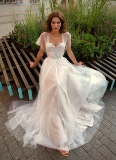 a woman in a white dress sitting on a bench