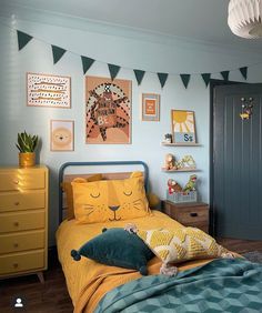 a child's bedroom decorated in blue and yellow with pictures on the wall above the bed