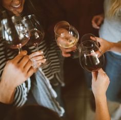 several people holding wine glasses in their hands