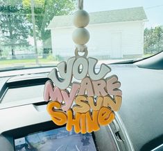 a car dashboard with the words you are my sunshine shine hanging from it's dash board