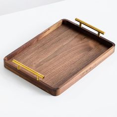 a wooden tray with two gold handles and a bar on the bottom that is attached to it