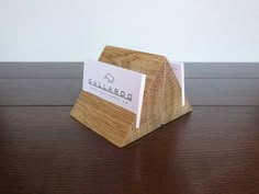 a business card holder made out of wood and burlied paper on top of a wooden table