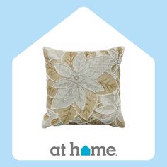 a decorative pillow with leaves on it and the words at home above it in blue