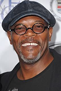 an older man with glasses and a hat smiling at the camera while standing in front of a wall