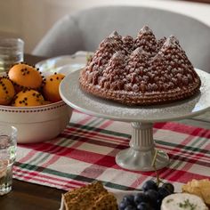 a bundt cake sitting on top of a table next to oranges and crackers