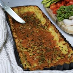 an omelet is sitting on a table with vegetables