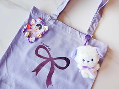 "ARMY! BORAHAE! Our Borahae ribbon tote is perfect for your army adventures~ Light purple tote featuring a metallic purple design. Featuring 2 metal D rings, this tote is ready to hold all of your keychains & photocard holders. Includes one zipper pouch for all your little things & a zipper top closure to keep everything safe. Tote bags measures approximately 15\" x 15.25\" with a flat base of 4\"  Inside zipper pouch measures 8.5\" x 6.75\" Tote Bags are NOT machine washable." Purple Kawaii Student Bag, Kawaii Purple Bag For Everyday Use, Harajuku Style Purple Shoulder Bag For Everyday, Purple Harajuku Shoulder Bag For Everyday Use, Kpop Tote Bag, Purple Kawaii Shoulder Bag, Purple Tote Bag, Funky Glasses, Purple Design