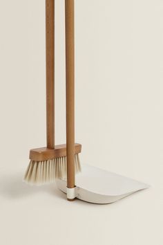 two wooden brooms with white bristles on them