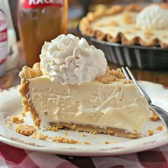 a piece of pie on a plate with a fork and ice cream in the background