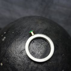 a metal ring sitting on top of a black rock