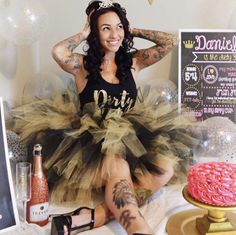 a woman sitting on top of a table next to a cake