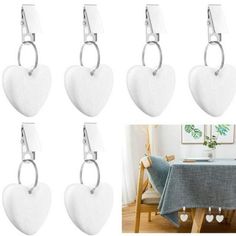 six white heart shaped hooks hanging on the wall next to a table with a blue chair