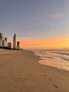 the beach is empty and there are buildings in the background