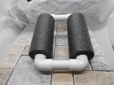 two black and white pipes sitting on top of a tiled floor